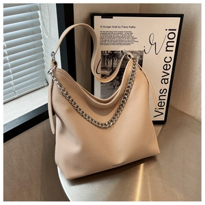 Dettaglio della texture in pelle litchi beige con tracolla a catena in metallo grosso