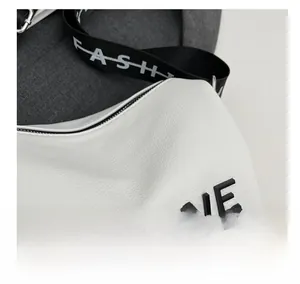 Detail of white lychee leather texture with black letter and nylon shoulder strap