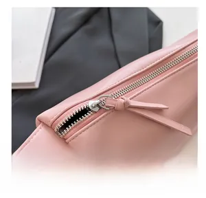 Close-up of pink leather handbag showing smooth silver metal zipper and premium texture
