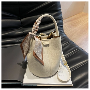Dettaglio borsa a secchiello in pelle litchi bianco sporco con manico foulard in seta