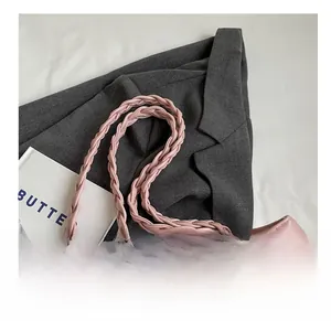 Close-up of pink quilted tote bag showing leather woven handles and zip closure detail