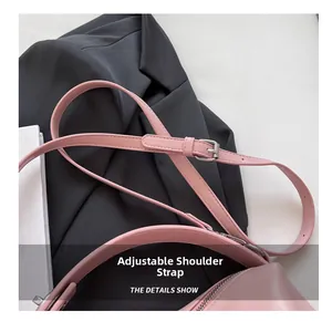 Detail showing the adjustable leather shoulder strap with silver buckle on the pink bag