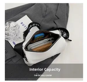 Internal capacity detail of white leather pillow bag with wide strap and zip pocket