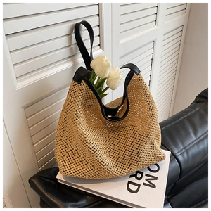 Macro view of woven straw bucket bag texture and premium black leather strap detail