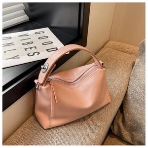 Detailed close-up of a pink faux leather handbag with silver twist lock on a soft background