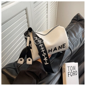 Detail of white litchi leather barrel bag featuring wide woven strap and HANE logo