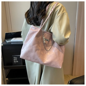 Pink quilted tote bag detail with woven strap, metal chain, and large pearl charms