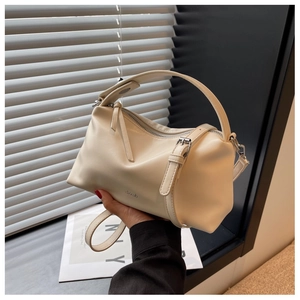 Detail of cream PU leather boston bag showing adjustable strap and silver hardware