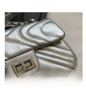 Close-up of silver chevron quilted leather texture and metallic turn-lock closure