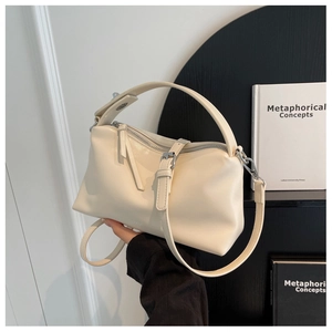 Detail of minimalist beige pillow bag with silver hardware and smooth leather finish