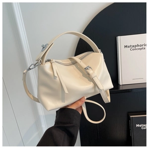 Close-up of cream pillow bag with silver hardware and adjustable wide shoulder strap
