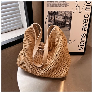 Detailed close-up of woven straw texture and premium leather handles on a summer tote bag