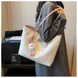 Detailed side view of beige tote bag with pink accents on a model for daily commute