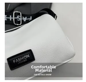 Détail montrant la texture du cuir blanc et l'étiquette mode noire sur le sac oreiller