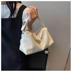 Detail of soft cream leather pillow bag featuring ruched cloud design and silver clasp