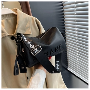 Detail of black pebbled leather cylinder bag with HANE embossed logo and fashion strap