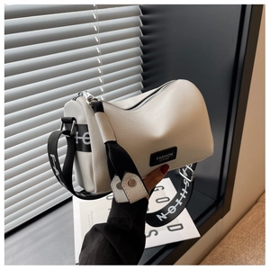 Détail du sac polochon blanc grainé avec sa bandoulière stylée noir et blanc tendance