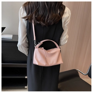 Crossbody view of a light pink pillow bag on a model showing size and soft leather texture