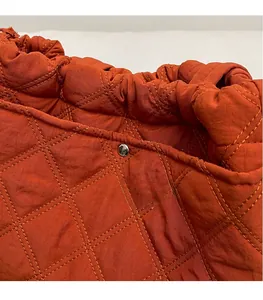 Détail du sac cabas matelassé caramel avec bouton pression argenté et bordure plissée