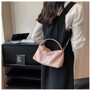 Detail of soft pink PU leather pillow bag with silver hooks and sleek handle