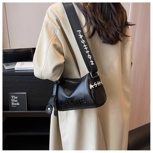 Close-up of black pebble leather pillow bag with a wide branded fashion shoulder strap