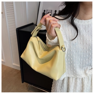 Detail of soft yellow leather pillow bag with wide handle and dimoh embossed logo