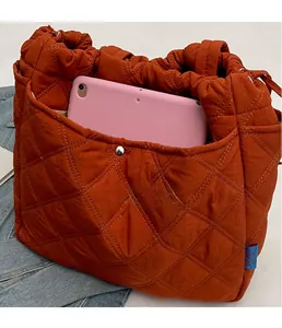 Gros plan du sac cabas matelassé orange avec poche frontale pour tablette numérique