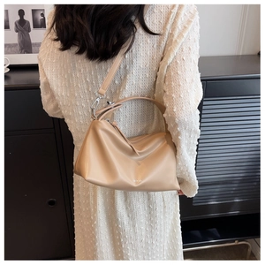 Detail of beige pleated shoulder bag with long strap and silver hardware accents