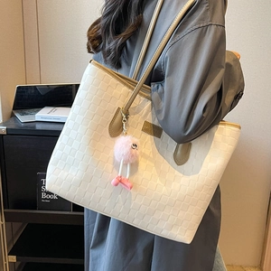 Large beige woven tote bag for women with khaki straps and pink plush charm