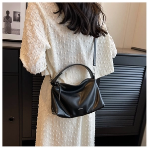 Detail showing the white printed logo on the soft black leather hobo bag with handle
