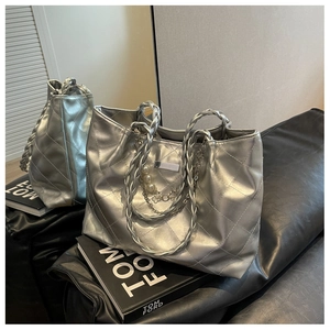 Detail of silver metallic tote bag featuring diamond quilting and pearl chain accents