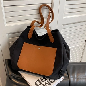 Large canvas tote bag with contrast brown pocket and shoulder strap for daily commuting