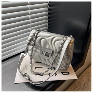 Close-up of wavy quilted silver shoulder bag with metallic finish and metal twist lock