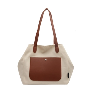 Minimalist off-white canvas tote bag with brown leather pocket and metal buckle detail