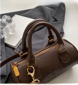 Detail of dark brown leather Boston bag showing MAJOR embossing and golden metal hardware