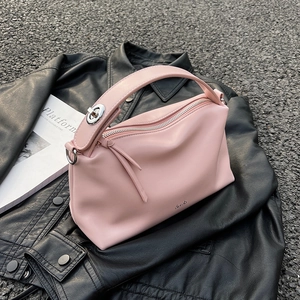 Elegant light pink leather pillow handbag with silver zipper for women on black jacket
