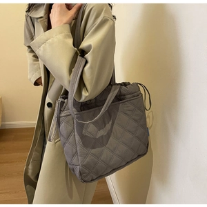 Close-up of quilted nylon tote bag featuring classic diamond stitching and drawstrings