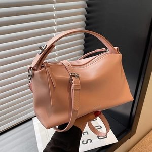 Pink fashion handbag with top handle and shoulder strap shown in aesthetic setting