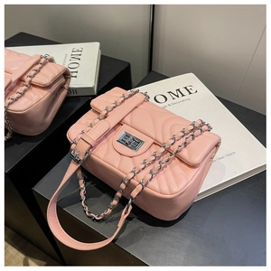 Close-up of pink quilted crossbody bag with silver chain strap and metal swivel lock