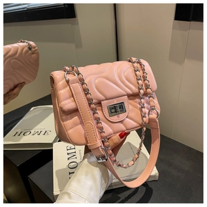 Detailed shot of pink wavy quilted PU leather surface with silver rotary lock and chain strap
