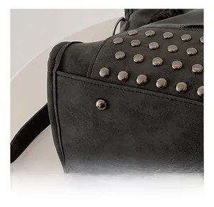 Dettaglio del fondo borsa in pelle scamosciata nera opaca con borchie in metallo