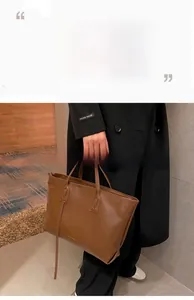 Detailed close-up of brown crocodile embossed PU leather tote bag with long handles