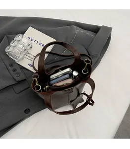 Vue de dessus d'un sac seau en cuir marron foncé montrant l'espace intérieur de rangement