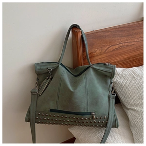 Dettaglio macro della borsa tote vintage con borchie argentate e nappa decorativa