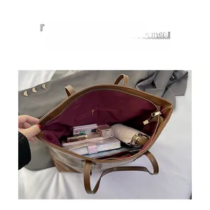 Spacious interior of brown leather tote bag with wine red lining and zip pocket