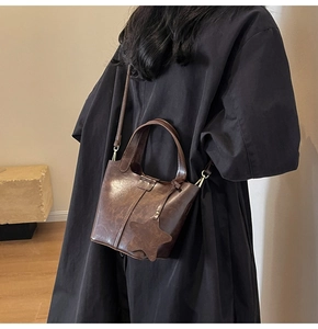 Vue détaillée d'un sac seau vintage en cuir PU marron foncé avec breloque étoile et sangle