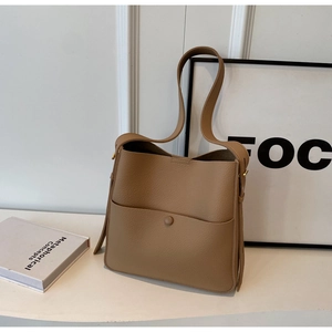 Detalle de bolso bucket de cuero granulado marrón claro con bolsillo y hebilla