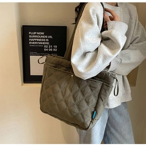 Quilted tote bag in olive green nylon with rhombic patterns and side drawstring detail