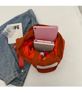 Draufsicht auf große orangefarbene Nylontasche mit viel Stauraum für Tablet und Notizblock