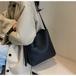 Detalle del bolso cubo grande negro de cuero texturizado con cierre magnético